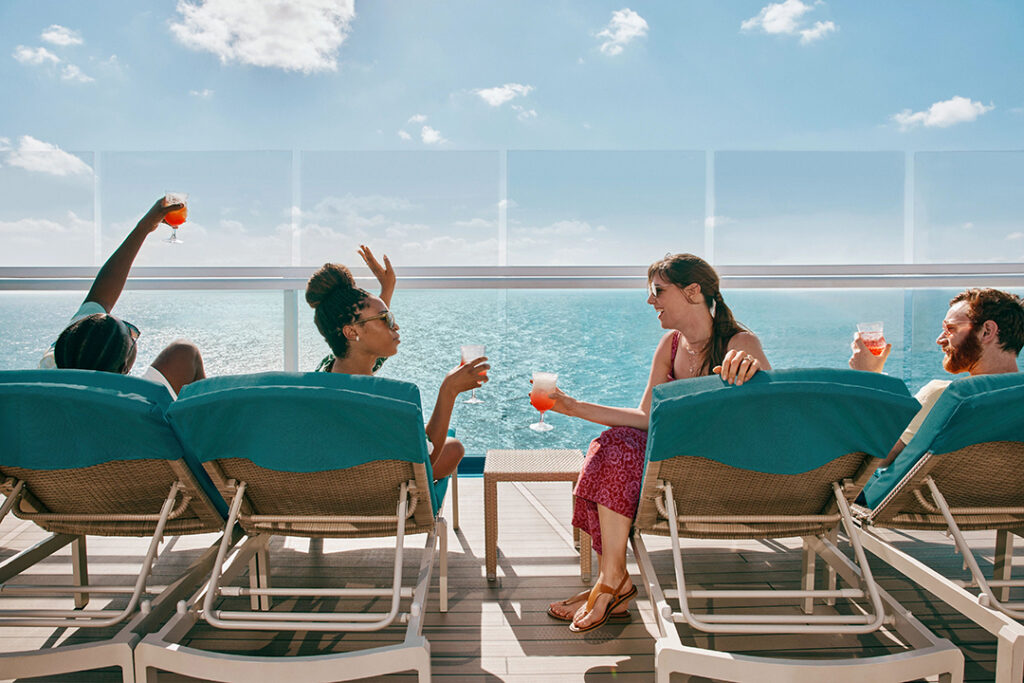 Cruising couples enjoy drinks, conversation, and cocktails on the outer deck. Image courtesy of Carnival Cruise Line.