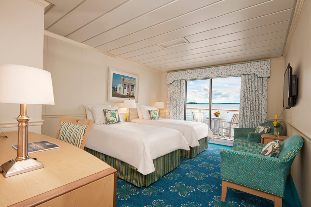 The 350-sq.-ft., Deluxe Balcony stateroom with twin-bed configuration aboard American Constitution. Image courtesy of American Cruise Line.