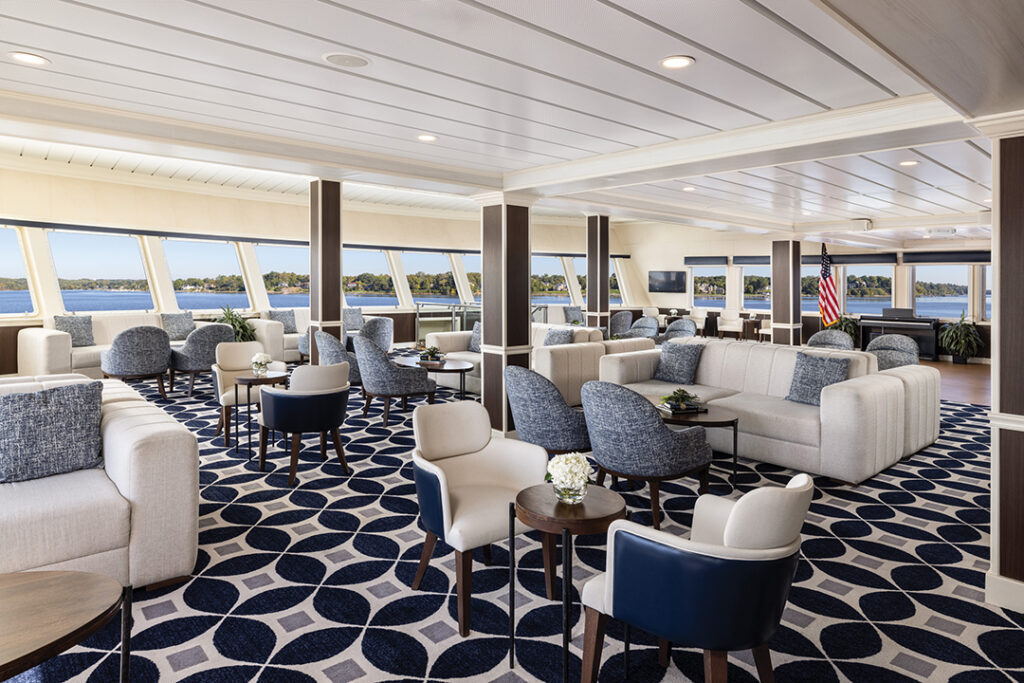 The Chesapeake Lounge aboard American Constitution offers panoramic views and a relaxed setting for socializing and scenic cruising. Image courtesy of American Cruise Line.