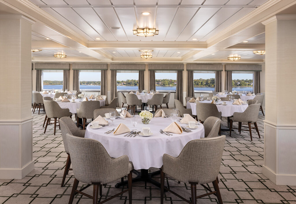 The main restaurant aboard American Constitution offers elegant, panoramic dining. Image courtesy of American Cruise Line.