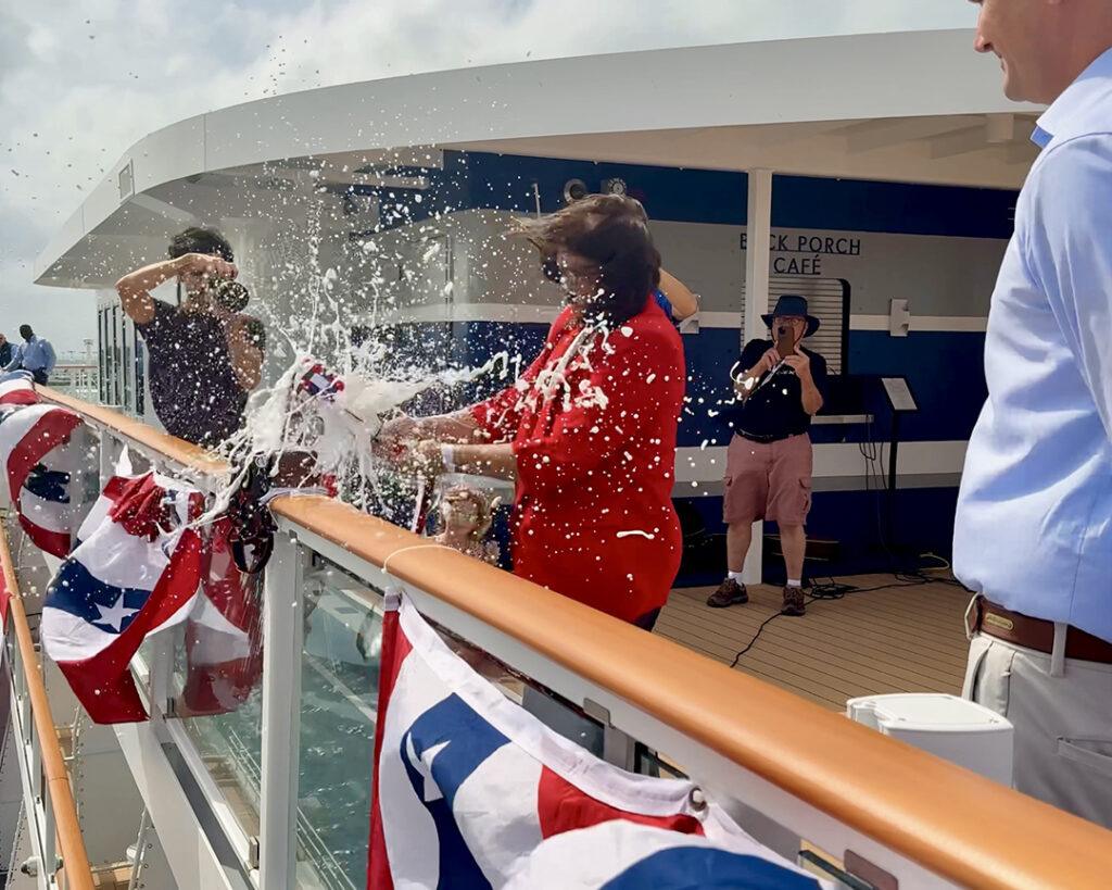 Key West Mayor Danise “Dee Dee” Henriquez breaks a champagne bottle to christen American Pioneer during a ceremony aboard the ship while docked at Mallory Square on Monday. Photo credit: CruiseNews.