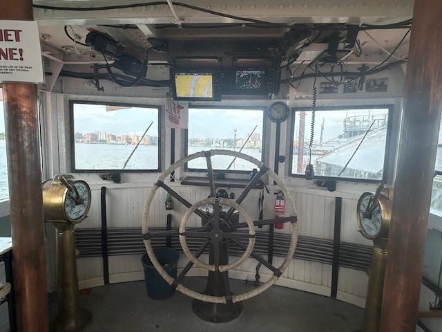 Inside the wheelhouse, John J. Harvey’s vintage helm and brass engine telegraphs stand ready. Image courtesy of Save Our Ships New York.