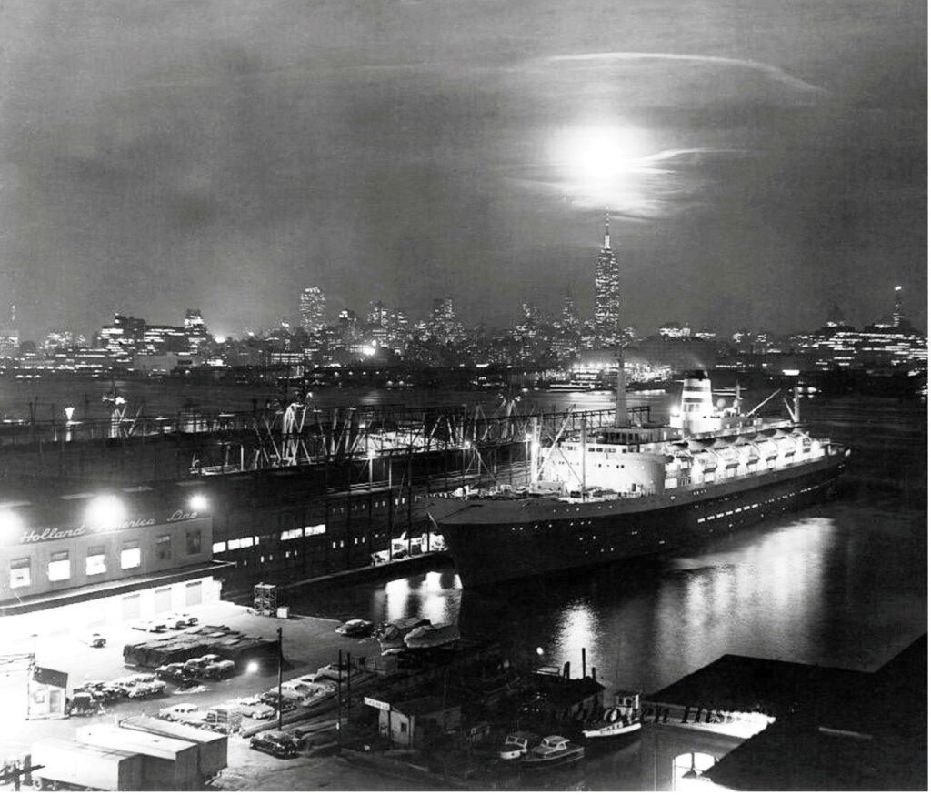 Statendam glows under the night sky at Holland America’s Hoboken pier, with the Manhattan skyline rising brightly across the Hudson. From the William H. Miller collection.