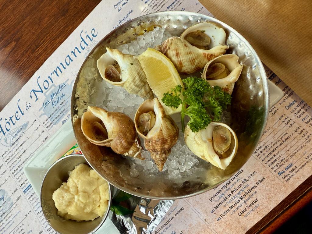 A plate of whelks on ice served with lemon and mayonnaise at the restaurant of Hôtel de Normandie in Évreux. Credit: Monte Mathews.