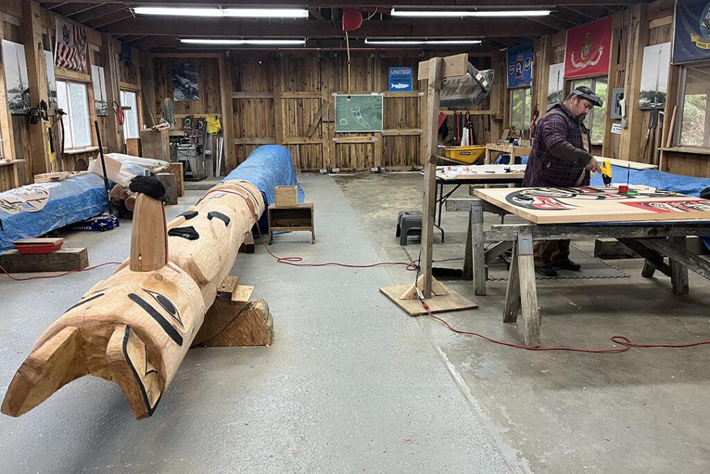An Indigenous artist works inside a carving shed in Klawock, Alaska. Photography by Richard Dalton III and courtesy of Huna Totem Corporation.