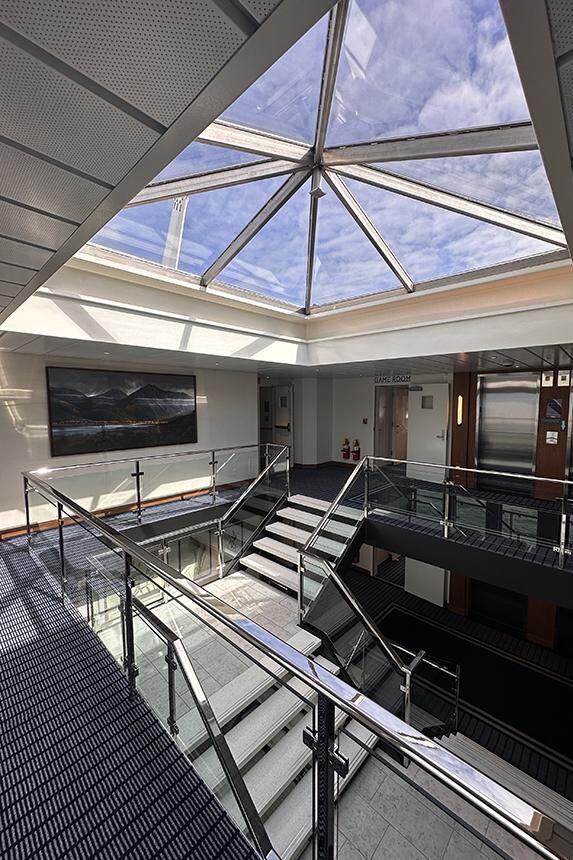 The light-filled atrium aboard American Encore connects the ship’s decks beneath a glass skylight. Photo: Gerry Barker