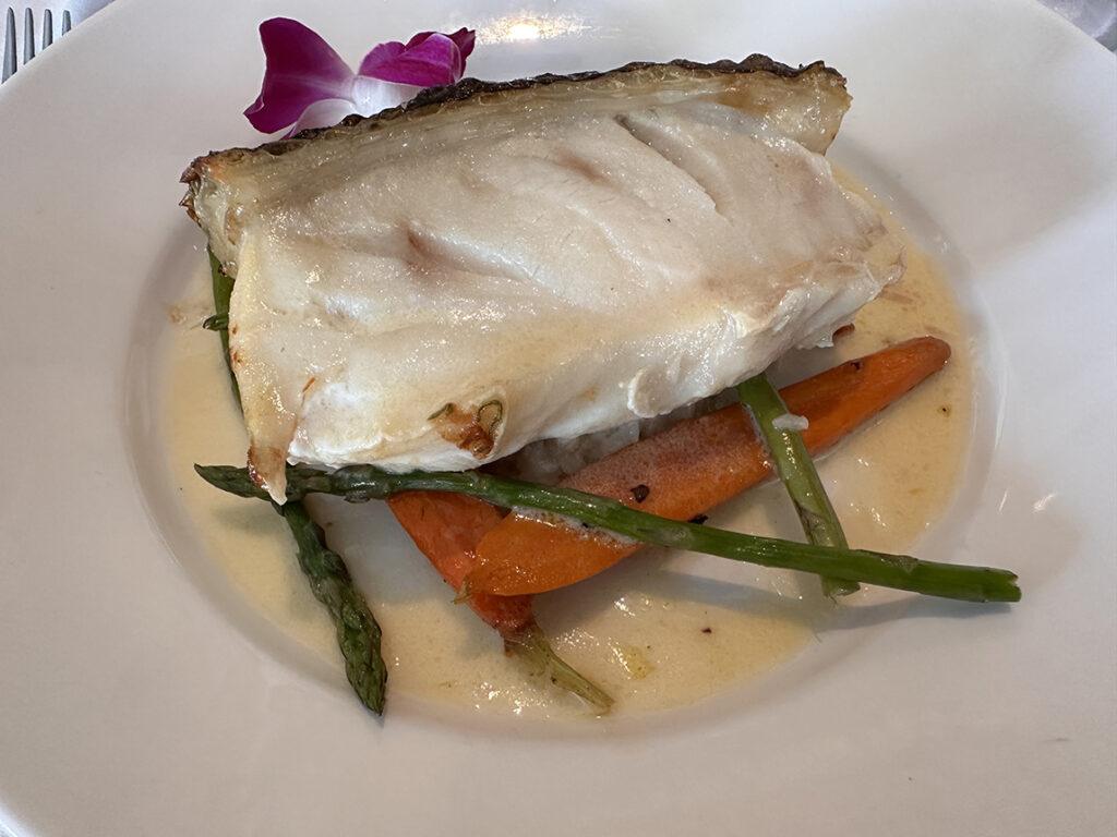 Crispy-skin sea bass is served with champagne risotto, thyme baby carrots, asparagus and champagne beurre blanc aboard American Encore. Photo: Gerry Barker