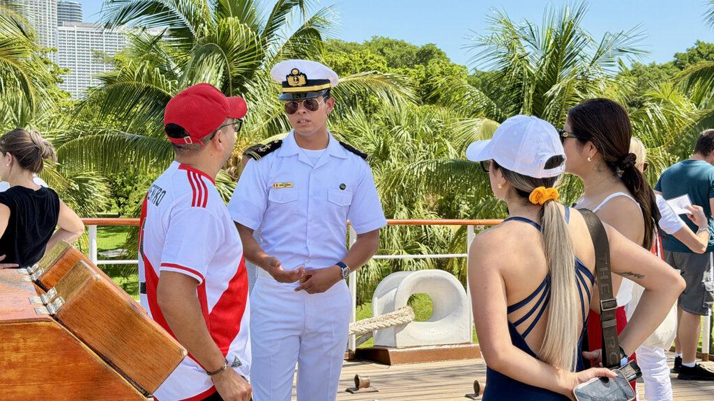 A Peruvian Navy crew member aboard B.A.P. Unión speaks with visitors during the tall ship’s public opening in Miami. Photo: H. Liu