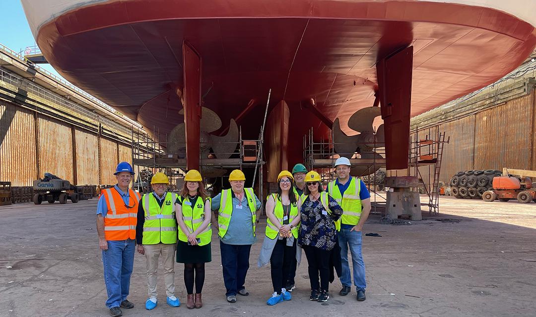 Monte Mathews, second from left, and Villa Vie founder Mikael "Mike" Petterson and the British Press group beneath Villa Vie Odyssey in drydock in Belfast. Photo: Monte Mathews