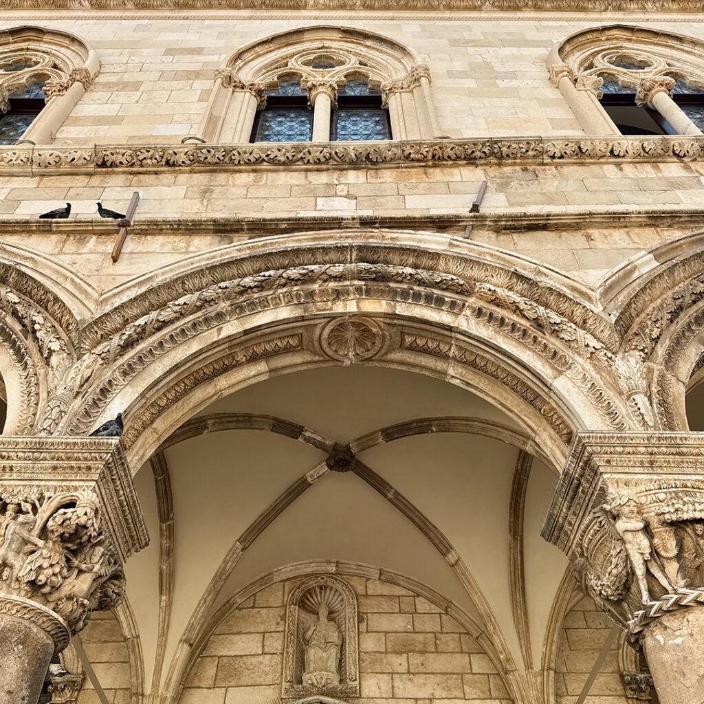 Ornate arches and carved stonework frame the loggia of the Rector’s Palace in Dubrovnik. Credit: Monte Mathews